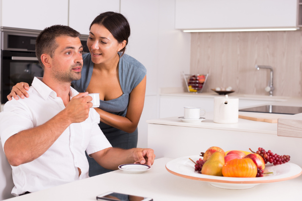 A woman and a man drinking tea in a kitchen